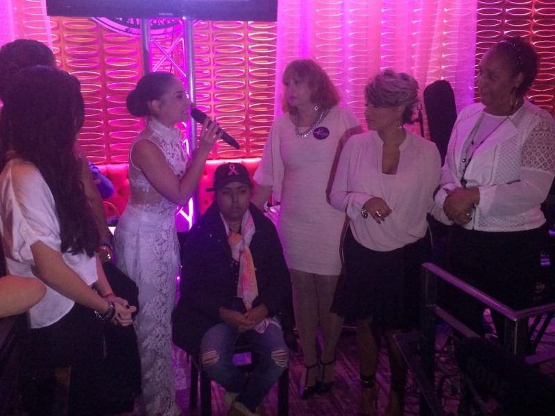 Diana Victoria, maestra de ceremonia, pronunció los nombres de las beneficiadas de la noche. Johendy Peralta (sentada), María Isabel Santana (parada, izquierda), Krailes Flores (parada, centro), Ana Cynthia Ávila (parada, derecha) le acompañan en tarima.